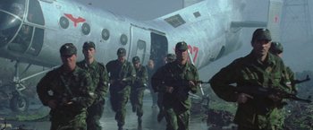 Movie still from “Godzilla” (1998), directed by Roland Emmerich – A group of men in fatigues are walking near an airplane; Wide shot, Low angle