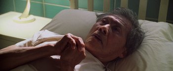 Movie still from “Godzilla” (1998), directed by Roland Emmerich – An older man laying in a hospital bed; Close Up shot, High angle