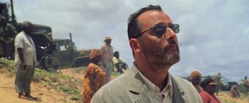 Movie still from “Godzilla” (1998), directed by Roland Emmerich – A person wearing a suit and sunglasses; Close Up shot, Low angle