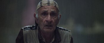 Movie still from “Godzilla” (1998), directed by Roland Emmerich – An old man wearing a hat looking at the camera; Close Up shot, Low angle