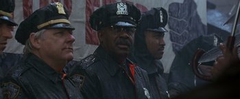 Movie still from “Godzilla” (1998), directed by Roland Emmerich – A group of police officers standing next to each other in the rain; Medium shot, Low angle