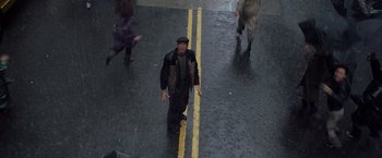 Movie still from “Godzilla” (1998), directed by Roland Emmerich – A man walking down the street in the rain; Wide shot, Overhead angle