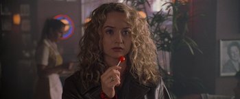 Movie still from “Godzilla” (1998), directed by Roland Emmerich – A person holding a lollipop; Close Up shot, Over the shoulder angle