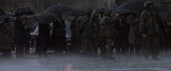 Movie still from “Godzilla” (1998), directed by Roland Emmerich – A group of people standing in the rain holding umbrellas; Extreme Wide shot, High angle