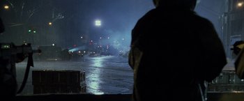 Movie still from “Godzilla” (1998), directed by Roland Emmerich – A man standing in front of a body of water at night; Extreme Wide shot, High angle