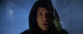 Movie still from “Godzilla” (1998), directed by Roland Emmerich – A man in a black jacket and a black hooded jacket; Close Up shot, Low angle