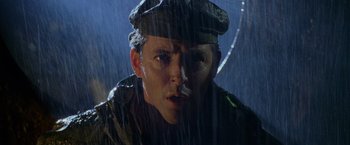 Movie still from “Godzilla” (1998), directed by Roland Emmerich – A person wearing a hat in the rain; Close Up shot, Low angle
