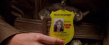 Movie still from “Godzilla” (1998), directed by Roland Emmerich – A police department badge with a woman's face on it; Extreme Close Up shot, Overhead angle