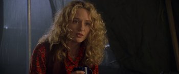Movie still from “Godzilla” (1998), directed by Roland Emmerich – A person with curly hair holding a cup; Close Up shot, Over the shoulder angle