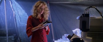Movie still from “Godzilla” (1998), directed by Roland Emmerich – A woman in a red dress holding a book; Medium shot, Low angle
