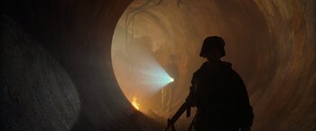 Movie still from “Godzilla” (1998), directed by Roland Emmerich – Two men are standing in a tunnel with a light on it; Wide shot, Low angle