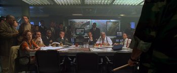 Movie still from “Godzilla” (1998), directed by Roland Emmerich – A group of men sitting around a table in front of a map; Wide shot, High angle
