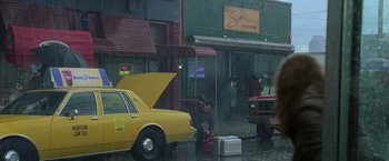 Movie still from “Godzilla” (1998), directed by Roland Emmerich – A man is standing in front of a car in the pouring rain; Extreme Wide shot, Low angle
