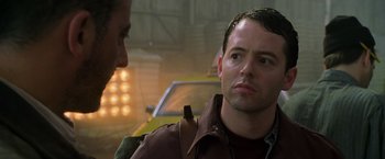 Movie still from “Godzilla” (1998), directed by Roland Emmerich – A man standing next to another man near a yellow car; Close Up shot, Over the shoulder angle