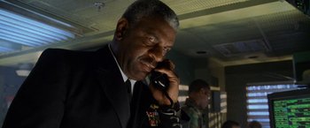 Movie still from “Godzilla” (1998), directed by Roland Emmerich – A man in a military uniform talking on a phone; Close Up shot, Low angle