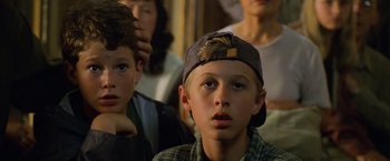 Movie still from “Godzilla” (1998), directed by Roland Emmerich – A group of people that are sitting in a room; Close Up shot, High angle