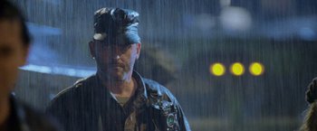 Movie still from “Godzilla” (1998), directed by Roland Emmerich – A man wearing a hat standing in the pouring rain; Close Up shot, Low angle