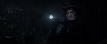 Movie still from “Godzilla” (2014), directed by Gareth Edwards – A man holding a flashlight in a dark forest; Close Up shot, Low angle