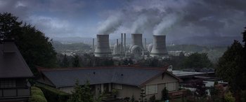 Movie still from “Godzilla” (2014), directed by Gareth Edwards – Smoke billows out of the chimneys of a power plant; Extreme Wide shot, High angle