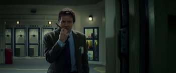 Movie still from “Godzilla” (2014), directed by Gareth Edwards – A man in a suit and tie holding a cell phone; Close Up shot, Low angle