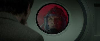 Movie still from “Godzilla” (2014), directed by Gareth Edwards – A man wearing a helmet looking into a porthole; Close Up shot, Over the shoulder angle