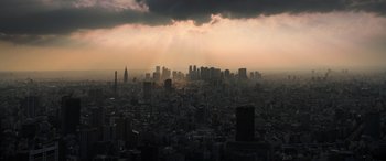 Movie still from “Godzilla” (2014), directed by Gareth Edwards – A view of a city skyline with a cloudy sky in the background; Extreme Wide shot, High angle