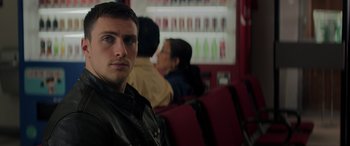 Movie still from “Godzilla” (2014), directed by Gareth Edwards – A man sitting on a bench in a room; Close Up shot, Over the shoulder angle