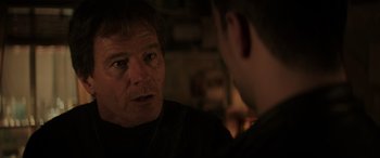 Movie still from “Godzilla” (2014), directed by Gareth Edwards – A man talking to another man in a dark room; Close Up shot, Over the shoulder angle