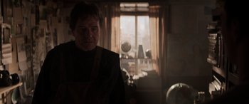 Movie still from “Godzilla” (2014), directed by Gareth Edwards – A man standing in front of a window in a room; Medium shot, Low angle