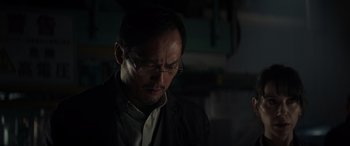 Movie still from “Godzilla” (2014), directed by Gareth Edwards – A man with glasses is looking down at the ground; Close Up shot, Low angle