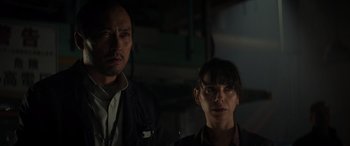 Movie still from “Godzilla” (2014), directed by Gareth Edwards – A man and a woman standing next to each other in the dark; Close Up shot, Low angle