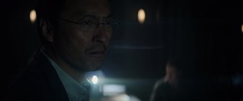 Movie still from “Godzilla” (2014), directed by Gareth Edwards – A person wearing glasses and a white shirt; Close Up shot, Low angle
