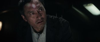 Movie still from “Godzilla” (2014), directed by Gareth Edwards – A person wearing a suit and tie; Close Up shot, Low angle