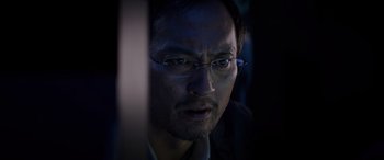 Movie still from “Godzilla” (2014), directed by Gareth Edwards – A person wearing glasses; Close Up shot, Low angle