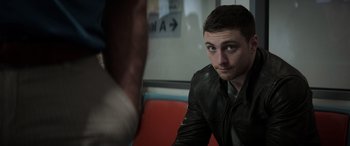 Movie still from “Godzilla” (2014), directed by Gareth Edwards – A man in a leather jacket sitting on a train; Close Up shot, Over the shoulder angle