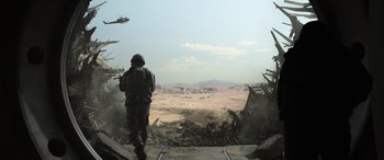 Movie still from “Godzilla” (2014), directed by Gareth Edwards – A soldier standing on a ramp looking out over a desert landscape; Extreme Wide shot, Low angle