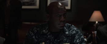 Movie still from “Godzilla” (2014), directed by Gareth Edwards – A man in a military uniform sitting in front of a wall; Close Up shot, High angle
