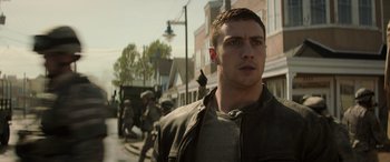 Movie still from “Godzilla” (2014), directed by Gareth Edwards – A young man standing on the side of the street; Close Up shot, Low angle