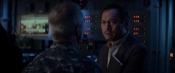 Movie still from “Godzilla” (2014), directed by Gareth Edwards – A man in a military uniform talking to another man in a suit; Close Up shot, Over the shoulder angle