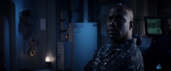 Movie still from “Godzilla” (2014), directed by Gareth Edwards – A man in a military fatigues is looking at the camera; Close Up shot, Over the shoulder angle