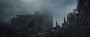 Movie still from “Godzilla” (2014), directed by Gareth Edwards – A building in the middle of a city in the fog; Extreme Wide shot, Low angle