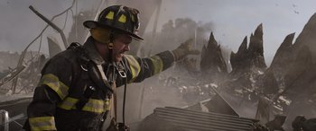 Movie still from “Godzilla” (2014), directed by Gareth Edwards – A fireman is pointing to a building that is on fire; Medium shot, Low angle