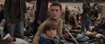 Movie still from “Godzilla” (2014), directed by Gareth Edwards – A man and a boy are standing in a parking lot; Close Up shot, Over the shoulder angle