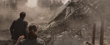 Movie still from “Godzilla” (2014), directed by Gareth Edwards – A woman is looking at a huge rock in the middle of a destroyed city; Extreme Wide shot, High angle