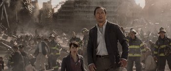 Movie still from “Godzilla” (2014), directed by Gareth Edwards – A man and a woman standing next to each other in front of a building; Medium shot, Low angle