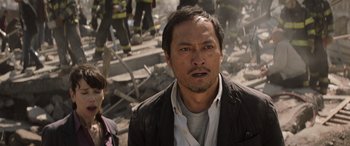 Movie still from “Godzilla” (2014), directed by Gareth Edwards – A person near a pile of rubble; Close Up shot, Over the shoulder angle