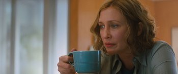 Movie still from “Godzilla: King of the Monsters” (2019), directed by Michael Dougherty – A woman is holding a cup of coffee; Close Up shot, Over the shoulder angle