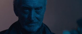 Movie still from “Godzilla: King of the Monsters” (2019), directed by Michael Dougherty – An old man with a beard is looking at the camera; Close Up shot, Low angle