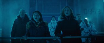 Movie still from “Godzilla: King of the Monsters” (2019), directed by Michael Dougherty – Two women and a child are standing in a dark room; Medium shot, Low angle