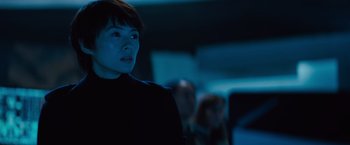 Movie still from “Godzilla: King of the Monsters” (2019), directed by Michael Dougherty – A woman standing in front of a group of other people; Close Up shot, Low angle